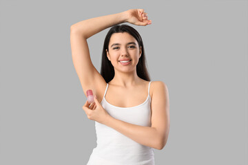 Happy smiling young woman using crystal deodorant on white background