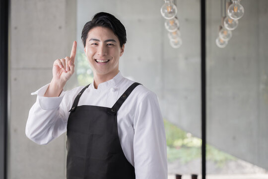 エプロンを着たシェフや飲食業で働く男性のイメージ　指さしのポイント　転職や採用にも