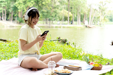 teenage girl is sitting happily relaxing and listening to music with headphones
