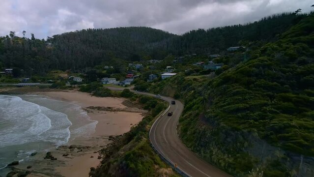 Cars drive along Australia's iconic Great Ocean Road coastal highway near Separation Creek town on cloudy day in Victoria