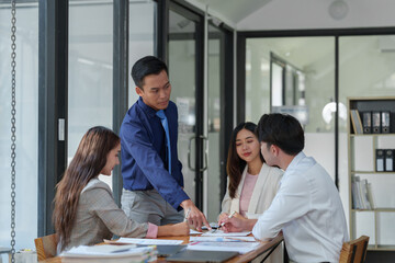 New-generation businessmen, creative professionals, and accountants meet to discuss business, brainstorm ideas, and project analysis reports. Check online investment results and company profits.