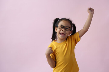 Close-up photo of a cute little girl, cheerful, smart, good at learning, new ideas, and imagination. Expressing various poses based on bright life concept, copy space, and pink pastel background.