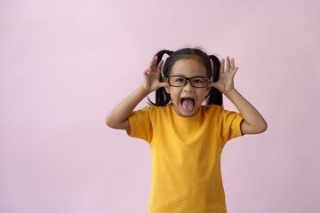 Close-up photo of a cute little girl, cheerful, smart, good at learning, new ideas, and imagination. Expressing various poses based on bright life concept, copy space, and pink pastel background.