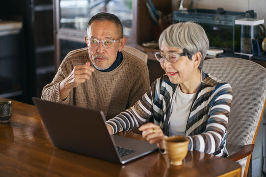 パソコンでインターネットを楽しむ日本人シニア夫婦