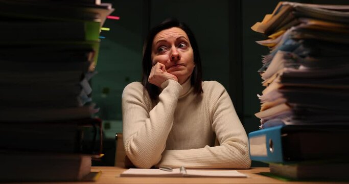 Tired office worker feels frustrated, overloaded with paperwork at night