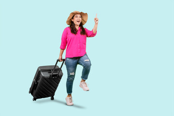 Happy excited woman carrying suitcase isolated over blue background