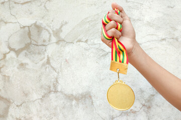 Hand of teenager showing the medal after win the game.