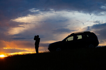 Active turism. mountain activities concept. Silhouette of a man near his off-road car.
