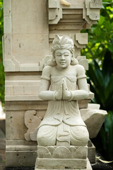 White Stone Deity Statue with Hands in Namaste Pose in Bali.