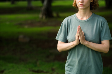 Women's hands folded in namaste, close-up, during meditation.