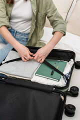 Unrecognizable woman packing a suitcase for a summer holiday abroad. Summer vacation. Traveling overseas.