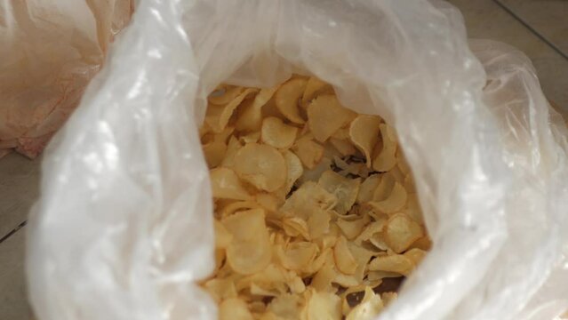 Cassava chips stored in plastic containers, taken for repackaging. Top view.