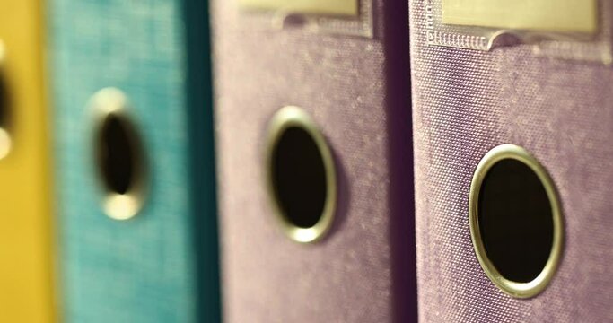 Closeup of row of five colorful office folders on shelf