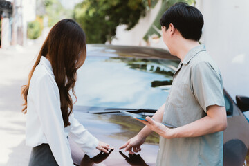 Young Asian female driver talking with car accident claim representative on the road, feeling stressed and concerned - obrazy, fototapety, plakaty