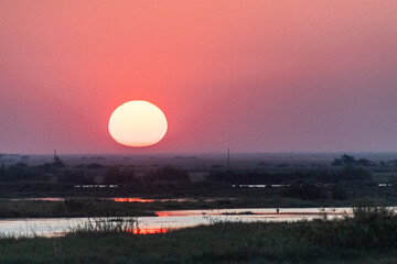 Telephoto shot of the setting sun over the chobe river on a bright winter afternoon in Botswana.