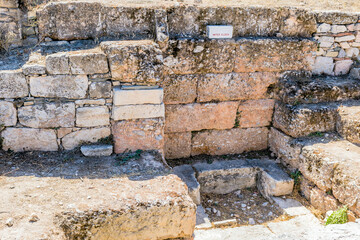 Sunlit ancient stone ruins of water clock at archaeological site in Athens, Greece