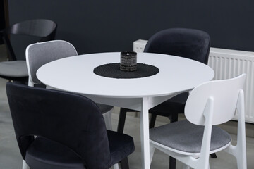 White wooden table complete with white and black wooden chairs with soft fabric upholstery. Black...