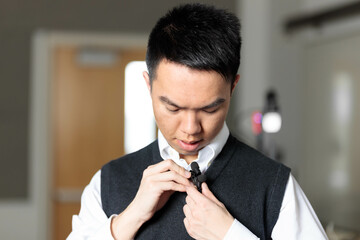 A tutor adjusts his lavalier microphone in preparation for a online class over video