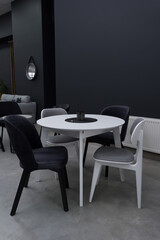 White wooden table complete with white and black wooden chairs with soft fabric upholstery. Black...