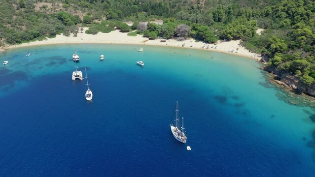 Aerial: Slow orbit drone shot of Tsougria island beach near Skiathos, Sporades, Greece with turquoise and emerald crystal clear water