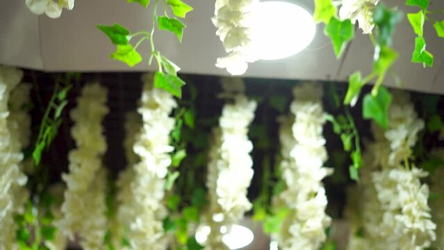 Delicate artificial flowers enhance the décor of the room's ceiling.