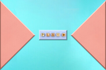 ピンクの三角形が向かい合う青い背景のPLAYの英語ブロックの押しボタン