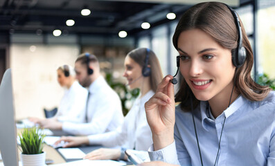 Portrait of call center worker accompanied by his team. Smiling customer support operator at work. - 785936730