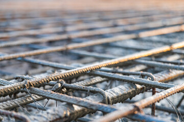 Pouring concrete for the reinforcement frame for the interfloor slab. Close-up, shallow depth of field.