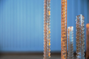 Steel bars, also known as steel reinforcement bars, are employed on construction sites to reinforce concrete, copy space, close-up and selective soft focus.