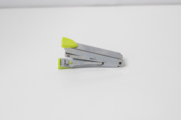 Silver colored stapler with green handle made of stainless steel