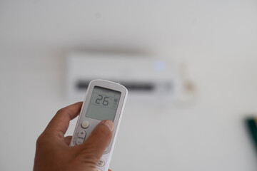 The AC remote pointing directly at the AC shows 26 degrees.