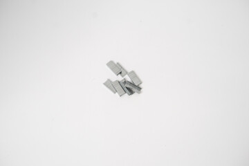 The contents of the stapler are collected severally on a white background - obrazy, fototapety, plakaty