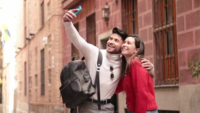 Close-up portraif of latin friends talking selfie in city street.