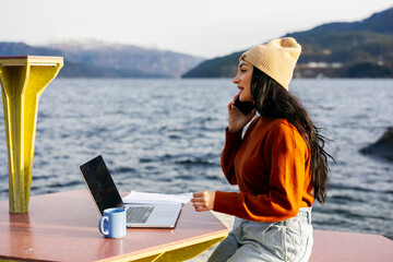 Young Woman Working Remotely by the Lake on a Sunny Day