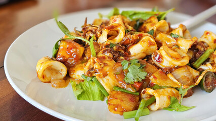 Stir Fried Squid with Chilli Paste. Thai Food. Fried Squid served with spicy sweet vegetables. Seafood octopus served and vegetables and red sauce.