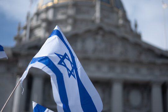 Demonstrators wave Israeli flags in front of San Francisco City Hall.
