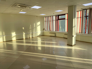 Interior of an empty room with windows and tiled floor. Office for rent.