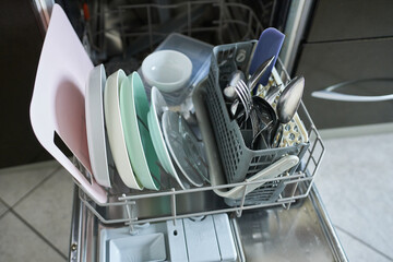 Dishwasher with clean utensils, closeup of photo