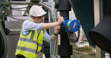 Civil engineer manager checking industry cooling air conditioner water cooling tower air chiller of...
