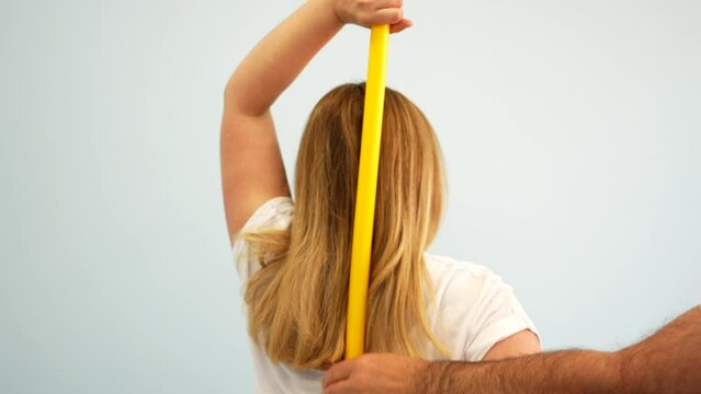 Blonde woman doing arm mobility exercises with physiotherapy instructor