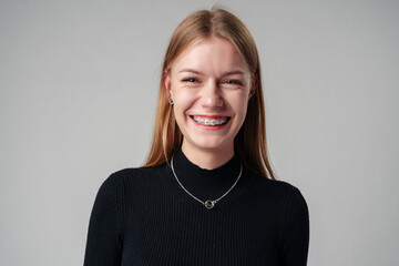 Smiling Woman in Black Top against gray background