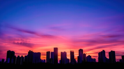 The silhouette of skyscrapers against a colorful sunset sky.