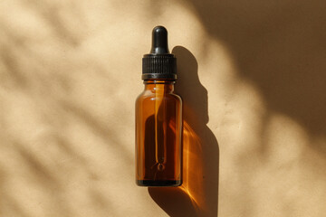 Naklejka premium A minimalist amber dropper bottle basks in the soft sunlight, casting a dynamic shadow on a textured background.