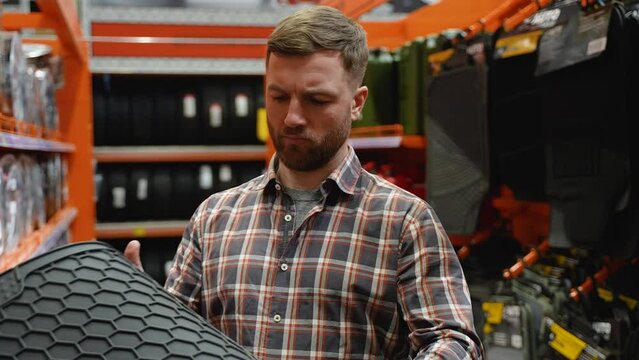 A man in auto shop chooses a new car mats