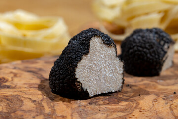 Cooking pasta with Italian black summer truffle, tasty aromatic mushroom, close up