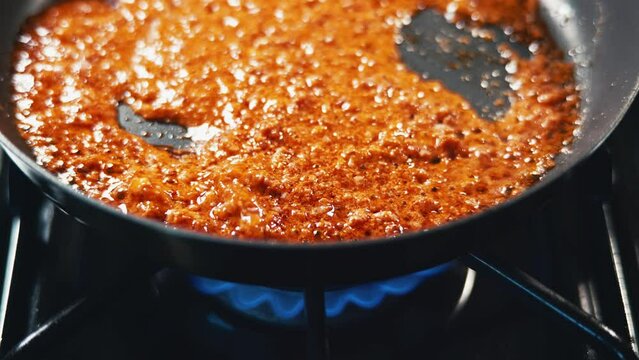 mexican chorizo cooking in a skillet on a gas stove handheld  
