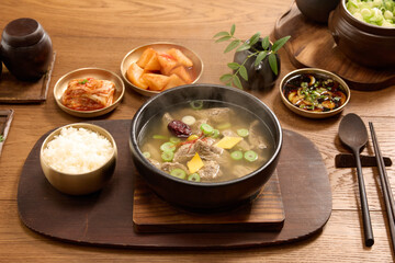 Hot rib gomtang, rice and soup in an earthen pot on a wooden background