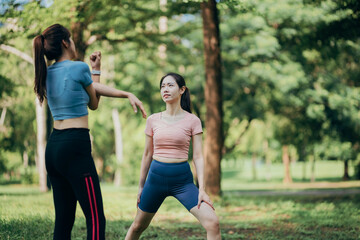 two Asian women engaging in physical activity within an urban park.