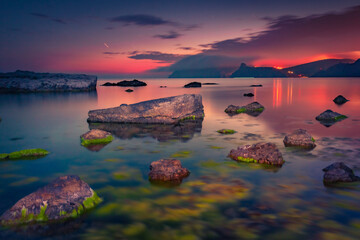 Dark red sky abowe the sea. Dramatic sunset on Balaklava bay. Calm summer seascape of Black Sea,...
