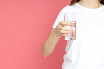 An attractive young girl with a glass of water in her hands